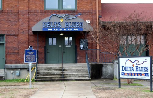 Exterior of the Delta Blues Museum in Clarksdale, Mississippi, featuring a sign and entrance with brick architecture.