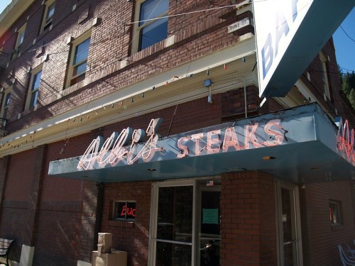 A brick building exterior featuring a neon sign that reads "Addie's Stears" above the entrance.