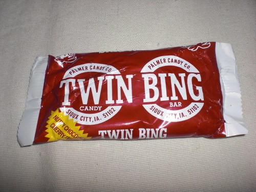 A red wrapper for a Twin Bing candy bar, featuring the brand name and location details.