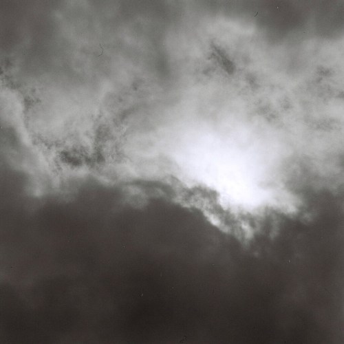 A dramatic sky filled with dark clouds, with a bright light peeking through the center.
