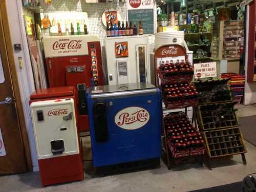 Vintage soda machines and a bottle rack featuring Coca-Cola and Pepsi-Cola in a nostalgic setting.