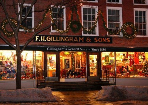 A festive general store with holiday decorations and lights, showcasing colorful merchandise in the windows.