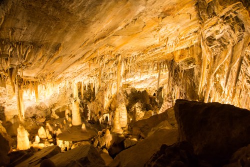 A stunning cave interior with illuminated stalactites and stalagmites, showcasing natural rock formations.