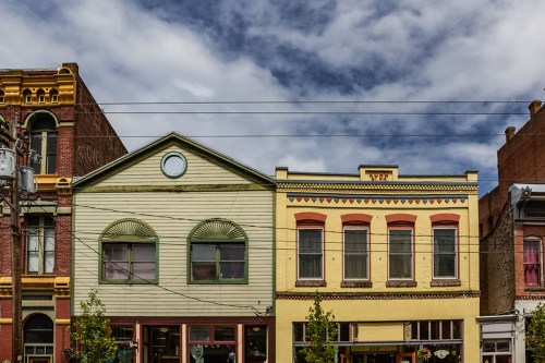 Historic buildings with colorful facades under a cloudy sky, featuring decorative architectural details.