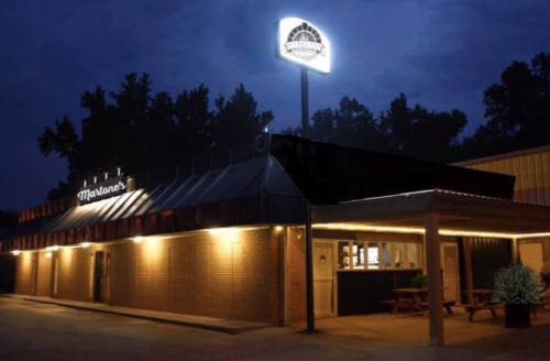 A dimly lit restaurant exterior at night, featuring a sign that reads "Marlane's" and warm lighting along the entrance.