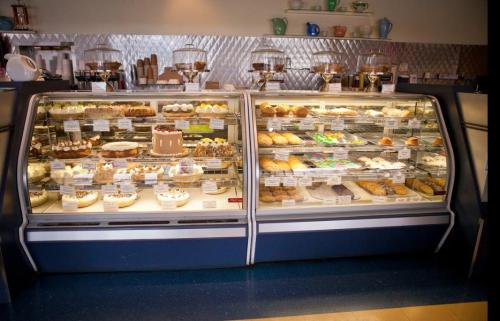 A display case filled with a variety of cakes, pastries, and desserts in a bakery setting.