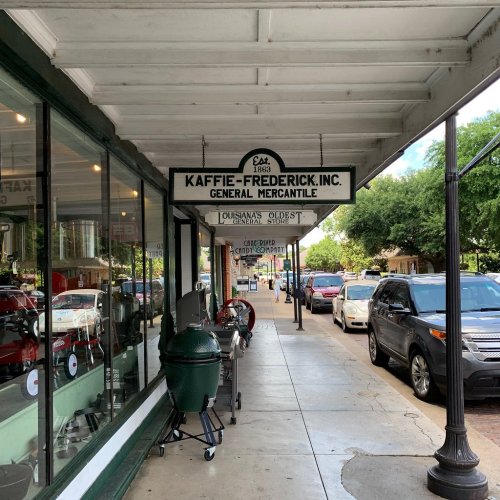 A street view of a historic mercantile store with a sign reading "Kaffie-Frederick, Inc." and parked cars nearby.