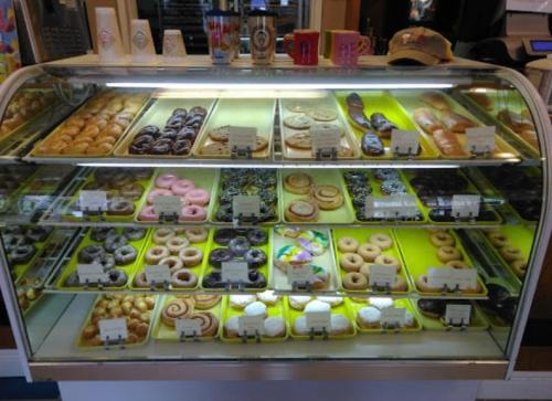 A display case filled with various donuts, including glazed, chocolate, and colorful options, all neatly arranged.