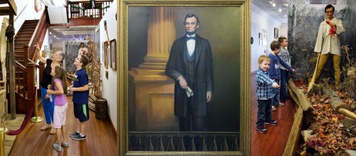 Visitors admire exhibits in a museum, including a portrait of Abraham Lincoln and a historical display.