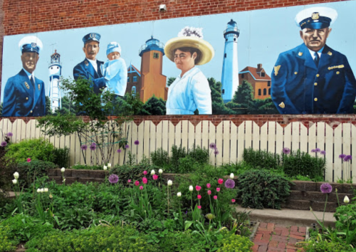 A colorful mural depicting historical figures in uniforms, set against a backdrop of a garden with blooming flowers.