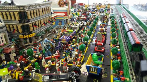 A vibrant LEGO city scene with crowds, vehicles, trees, and buildings, showcasing a lively miniature urban environment.