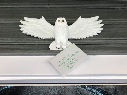 A white owl figurine with outstretched wings, accompanied by a note addressed to "Mr. Potter."