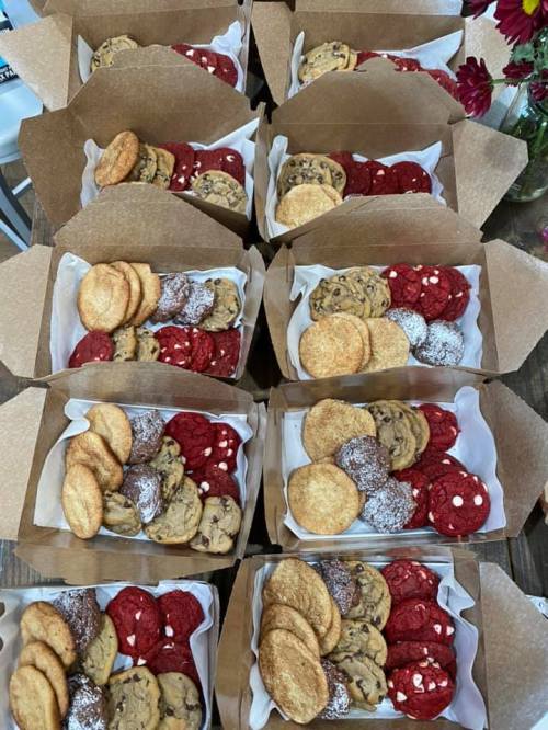 Aerial view of multiple boxes filled with assorted cookies, including chocolate chip, red velvet, and snickerdoodles.