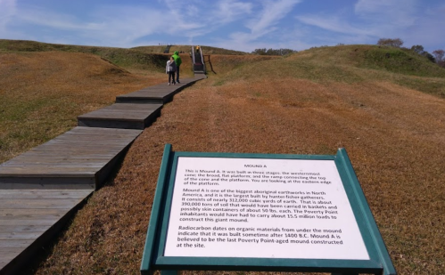 A wooden walkway leads to Mound A, an ancient earthwork, with a sign detailing its historical significance.
