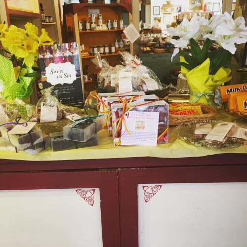 A colorful display of gift baskets, sweets, and flowers in a shop, featuring various treats and decorative items.