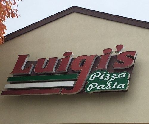 Sign for "Luigi's Pizza & Pasta" featuring red, green, and white colors on a building exterior.