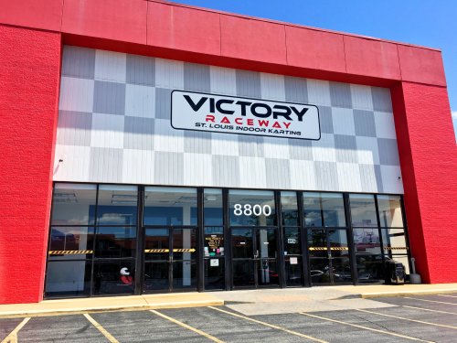 Exterior of Victory Raceway, an indoor karting facility in St. Louis, featuring a red building and large glass entrance.