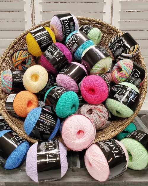 A woven basket overflowing with colorful yarn skeins in various shades and textures.