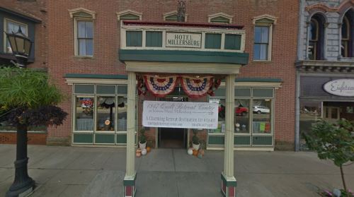 Front view of Hotel Millersburg, featuring a welcoming entrance with decorative banners and pumpkins.