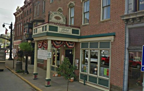 Historic hotel and restaurant with decorative awning and signage, featuring brick architecture and street view.