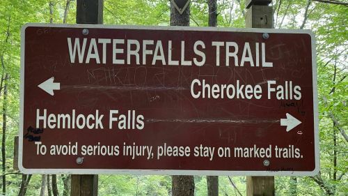 Sign for Waterfalls Trail with directions to Cherokee Falls and Hemlock Falls, warning to stay on marked trails.