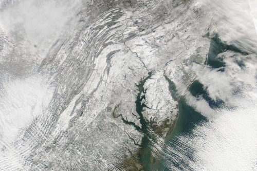 Satellite image showing a snow-covered landscape of the northeastern United States, including parts of New Jersey and New York.