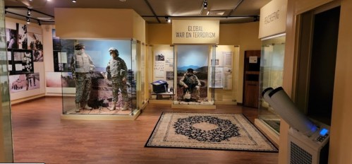 Exhibit showcasing the Global War on Terrorism, featuring military displays and informational panels in a museum setting.