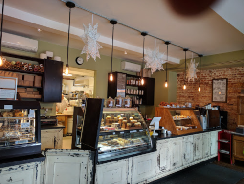 Cozy café interior with a display case of pastries, warm lighting, and decorative star-shaped ornaments hanging from the ceiling.