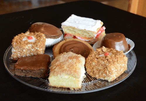 A platter of assorted desserts, including chocolate-covered treats, layered cakes, and sweet pastries.