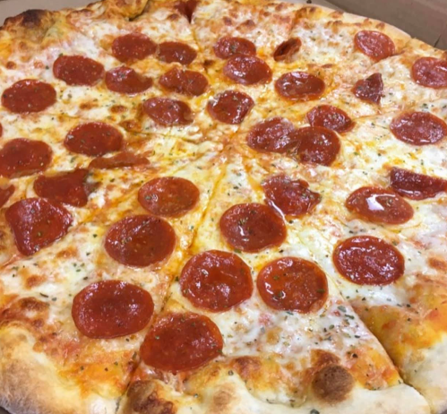 A close-up of a pepperoni pizza with melted cheese and a golden crust, sliced into equal pieces.