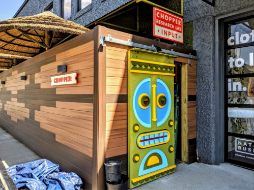 Colorful entrance to the Chopper Research Lab, featuring a tiki-style door and wooden paneling.