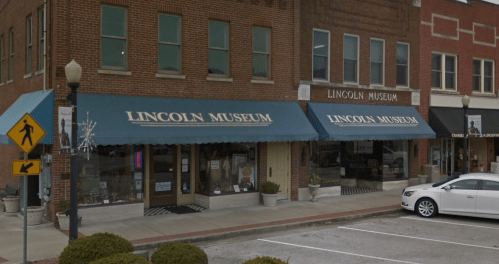 Exterior view of the Lincoln Museum, featuring brick walls and blue awnings with the museum's name displayed.