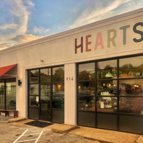 Exterior of a building with large windows, featuring the word "HEARTS" on the wall and a red awning.