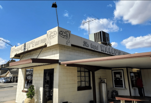 Exterior of Wally's Fast Food restaurant with a sign and blue sky in the background.