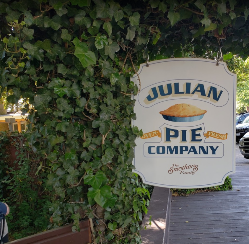 Sign for Julian Pie Company, featuring a pie graphic, surrounded by green ivy.