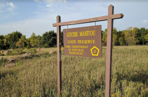 Sign for Gitchie Manitou State Preserve, Iowa Department of Natural Resources, surrounded by grassy landscape.