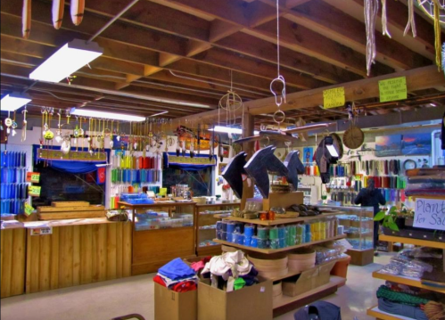 A colorful craft store interior with shelves of supplies, tools hanging from the ceiling, and various items displayed.