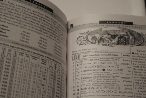 A close-up of an open calendar page for January 2011, featuring dates, events, and a quote at the top.
