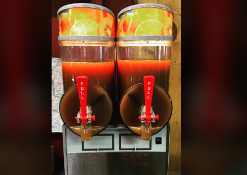 Two beverage dispensers filled with colorful drinks, featuring red "PULL" levers for serving.