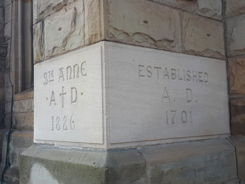 Stone corner of a building with inscriptions: "St. Anne A.D. 1886" and "Established A.D. 1701."