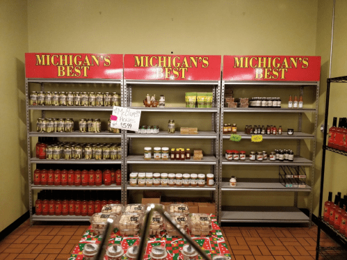 Shelves labeled "Michigan's Best" filled with various jars and products, showcasing local goods and snacks.
