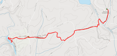 Map showing a red trail route along a winding path through hilly terrain, with water features and landmarks.