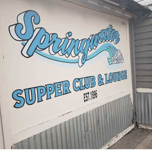 Sign for Springwater Supper Club & Lounge, featuring blue lettering and established in 1896.