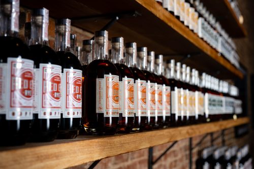 A close-up of shelves lined with various bottles of spirits, featuring distinct labels and colors.