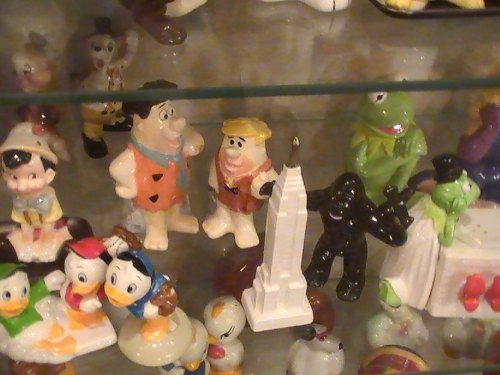 A display of colorful figurines, including cartoon characters and a miniature Empire State Building.