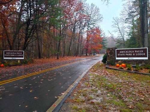 Entrance to Amicalola Falls State Park & Lodge, surrounded by autumn foliage and pumpkins on a rainy day.