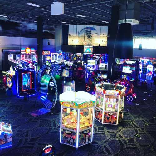 A vibrant arcade filled with colorful, illuminated games and machines, creating a lively atmosphere.