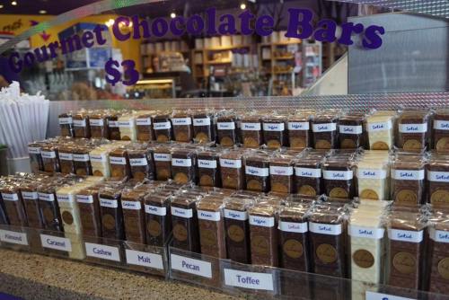 A display of gourmet chocolate bars in various flavors, priced at $3 each, arranged neatly on a counter.