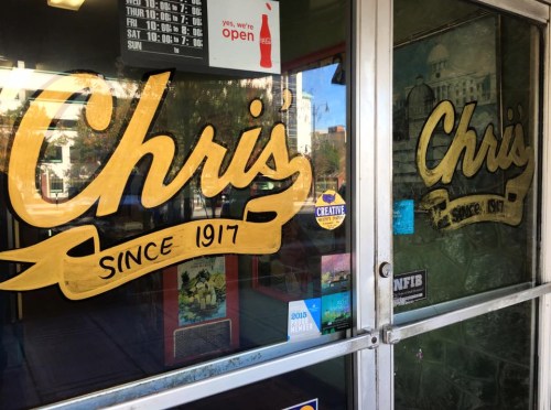 A glass door with the name "Chris" painted in gold, featuring the text "Since 1917" below it.