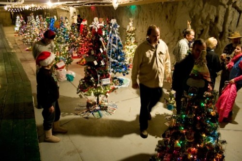 A festive underground space filled with decorated Christmas trees and people enjoying the holiday atmosphere.